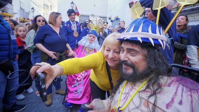 Una aficionada se hace un selfie en la plaza Pinto con el 'Cristo' de la chirigota del Cascana.